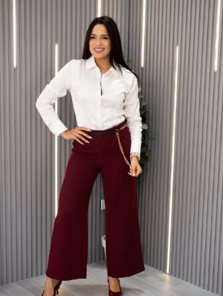 Modelo con camisa blanca y pantalón vino tinto en un studio
