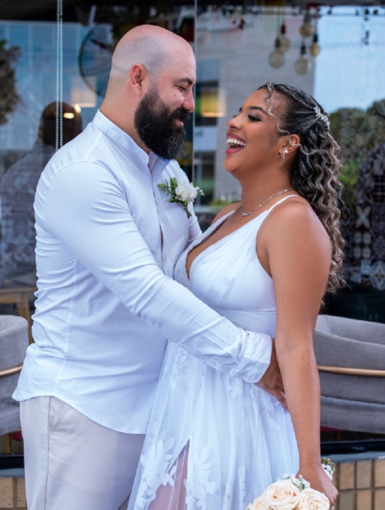 Pareja de novios abrazados y riendo el día de su boda
