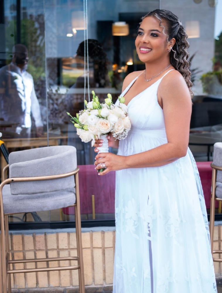 Novia sonriendo con su ramo en una terraza